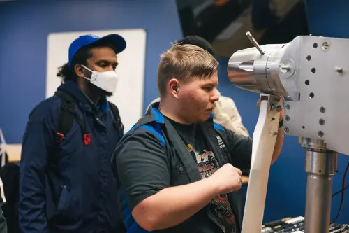 Wind turbine technician students working on a model turbine
