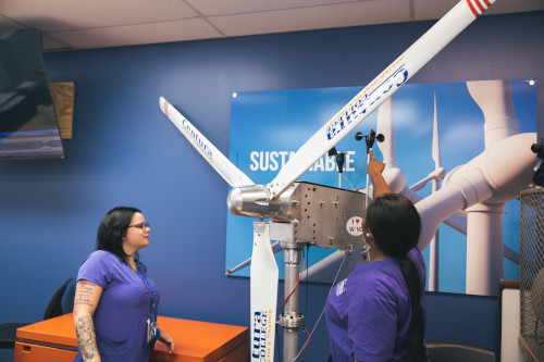 Students working on a model wind turbine in a classroom