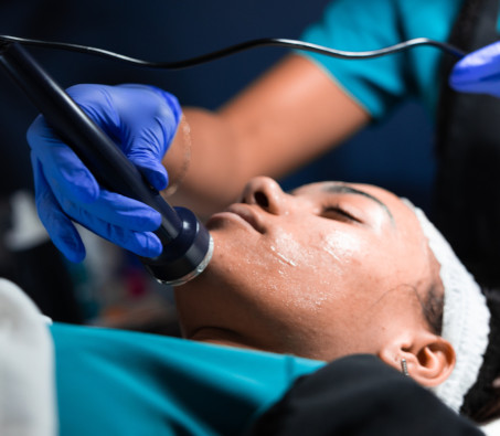 A Centura College master esthetician program student practicing a peel on another student