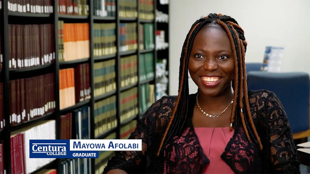 Centura graduate Mayowa Afolabi sitting in a chair in the school library