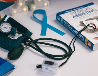 A blood pressure cuff and medical assisting textbook on a desk