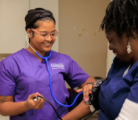A Centura College medical assistant program student checking the blood pressure of another student