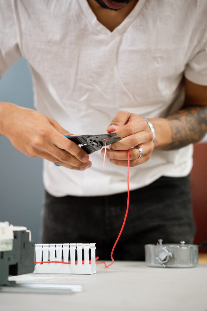 Hands-on training exercise showing a student becoming an electrician by learning to strip electrical wire at Centura College.
