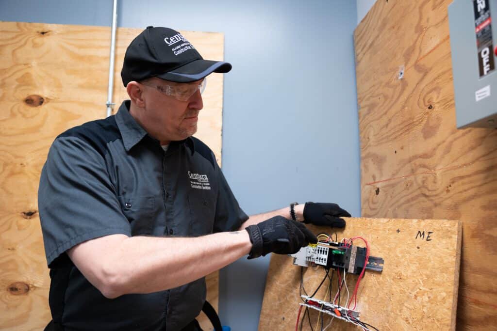 Electrician apprentice working on a hands-on wiring panel during the Centura College apprentice electrician program.