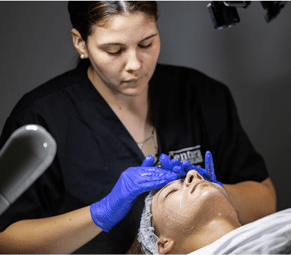 A Centura College professional esthetician program student cleaning the pores of another student